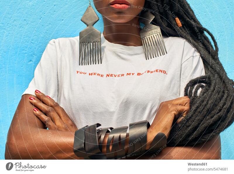 Porträt einer Frau mit langen Dreadlocks, die ein T-Shirt mit der Botschaft "Du warst nie mein Freund" vor einer türkisfarbenen Wand trägt Freunde Kameradschaft