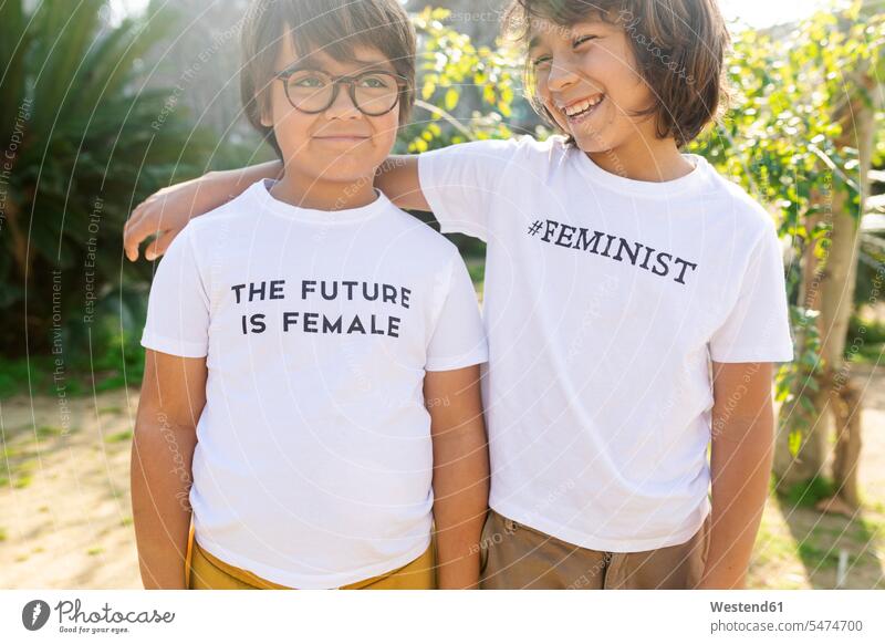 Zwei Jungen stehen mit einem Aufdruck auf einem T-Shirt auf der Straße und sagen: "Femininst und die Zukunft ist weiblich Freunde Kameradschaft T-Shirts freuen