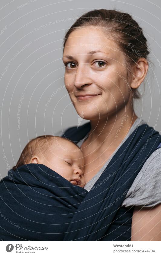 Porträt einer lächelnden Mutter mit Baby im Babytragetuch Babies Babys Säuglinge Kind Kinder Mami Mutti Mütter Mama Tragetücher Tragetuch Babytragetücher Mensch