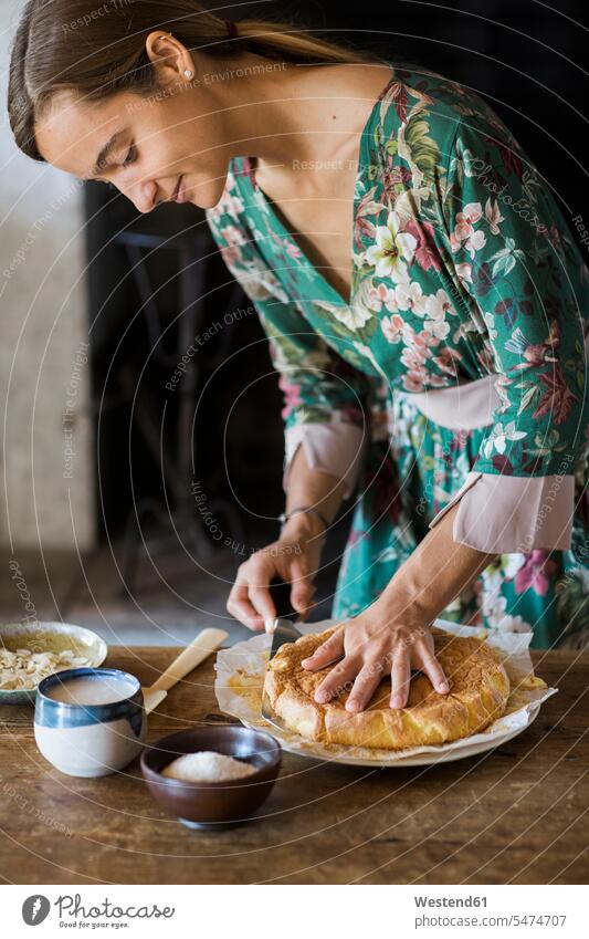 Junge Frau schneidet selbstgebackenen Kuchen an weiblich Frauen schneiden Süßspeise Süsses Süßes süß Süßspeisen Essen Food Food and Drink Lebensmittel