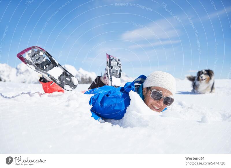 Österreich, Tirol, Schneeschuhwanderer und Hund amüsieren sich im Schnee lachen Freude freuen Winter winterlich Winterzeit fallen Sturz stuerzen hinfallen