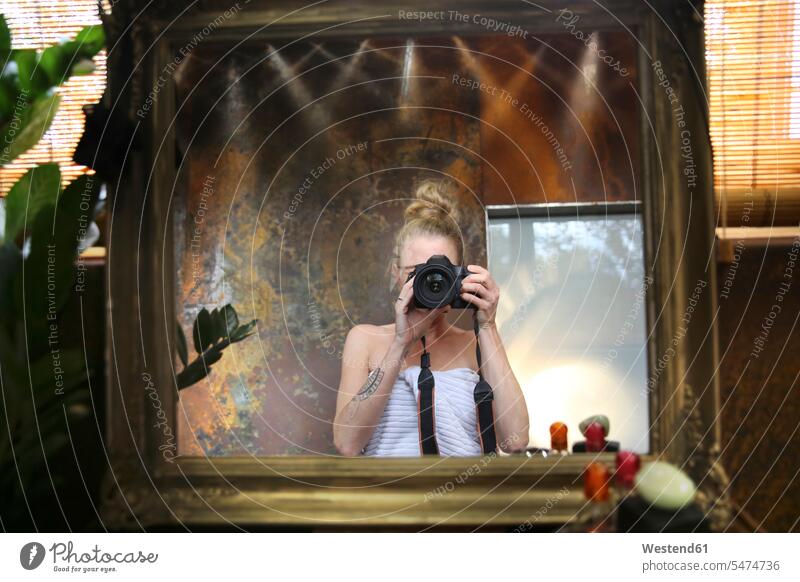 Spiegelbild einer Frau, die ein Selfie mit einer Kamera im Badezimmer macht Selfies weiblich Frauen Kameras Fotoapparat Fotokamera fotografieren Spiegelbilder