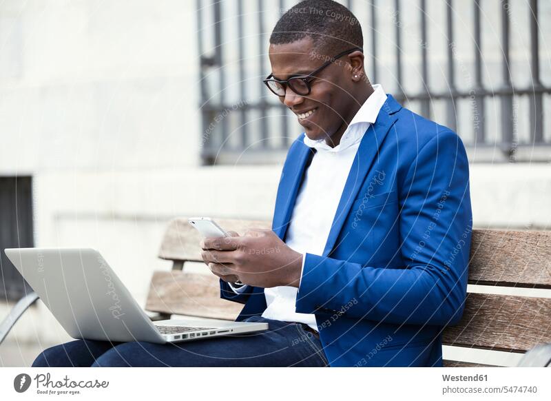Junger Geschäftsmann in blauer Anzugjacke sitzt auf Bank und benutzt Smartphone Job Berufe Berufstätigkeit Beschäftigung Jobs geschäftlich Geschäftsleben