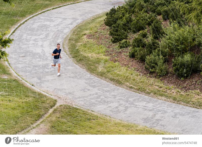 Sportlicher Mann joggt in einem Park rennen Muße fit gesund Gesundheit Jogging Leistungen Dynamik dynamisch Power Lebenstil Lifestyles beweglich Biegsamkeit