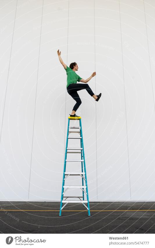 Acrobat beim Balancieren auf der Leiter Leitern balancieren Balance Akrobat Akrobaten stehen stehend steht Trainieren Übung Üben Übungen ausgeglichen