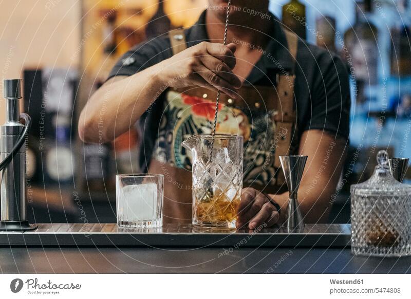 Barkeeper mixt Cocktail in einer Bar Job Berufe Berufstätigkeit Beschäftigung Jobs Gastronomie Barmann Flaschen Gläser Trinkglas Trinkgläser Arbeit Individuell