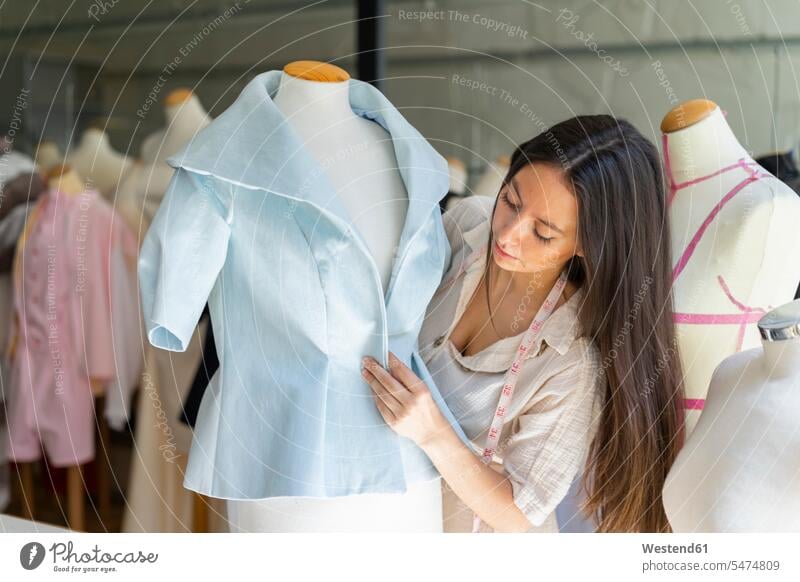 Junge Modedesignerin beim Anprobieren von Kleidern nach einem Schneidermodell Schneiderin Schneiderinnen Schneiderei Schneideratelier Schneiderwerkstaetten