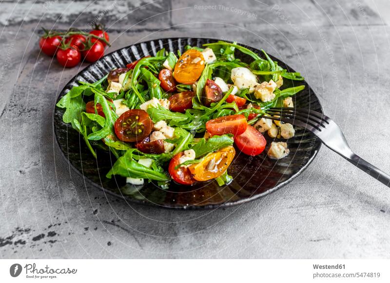 Teller mit vegetarischem Salat mit Rucola, Tomaten, Nüssen und Mozzarella-Käse Erhöhte Ansicht Erhöhte Ansichten Nahaufnahme close up close-up close ups