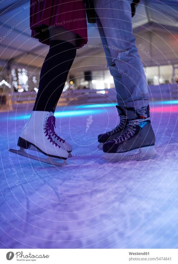 Beine eines Paares mit Schlittschuhen auf einer Eisbahn stehend Pärchen Partnerschaft Eislaufbahn Schlittschuhbahn steht Mensch Menschen Leute People Personen