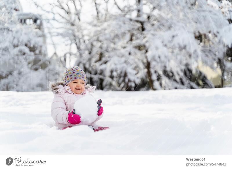 Nettes kleines Mädchen spielt mit Schnee im Winter winterlich Winterzeit niedlich süss süß putzig weiblich spielen Wetter Kind Kinder Kids Mensch Menschen Leute