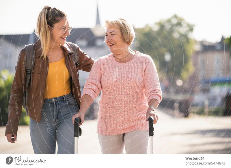 Enkelin hilft ihrer Großmutter beim Laufen mit einer Gehhilfe auf Rädern Generation Brillen gehend geht reden freuen Glück glücklich sein glücklichsein innig