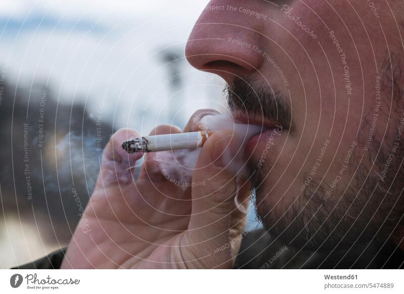 Detail von Raucher, Zigarette und Rauch Nikotinsucht Zigaretten halten Laster ungesund schlechte Angewohnheit Lasterhaftigkeit gesundheitsschaedlich