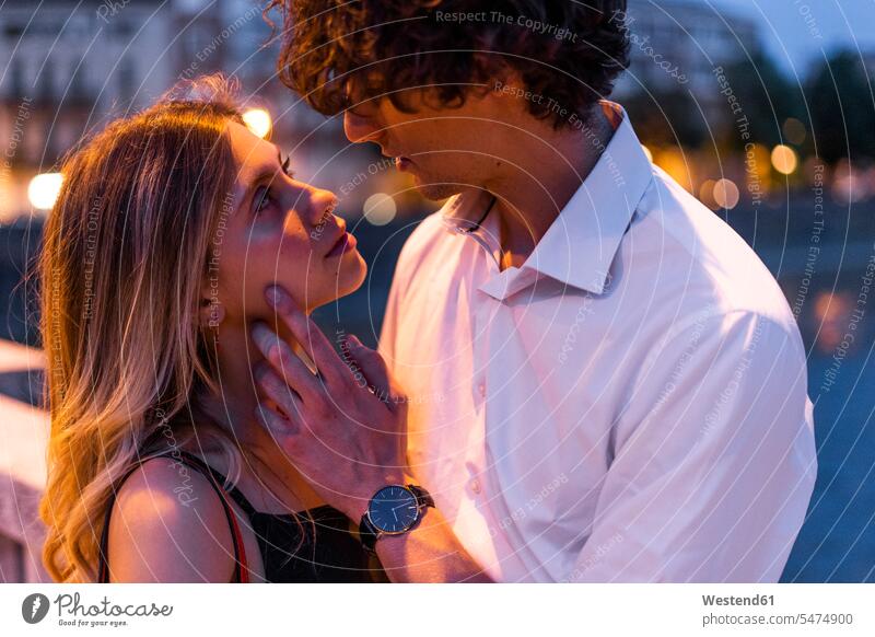 Affectionate junges Paar küssen in der Stadt in der Nacht Hemden anfassen Berührung Kuss Küsse abends nachts freuen geniessen Genuss Glück glücklich sein