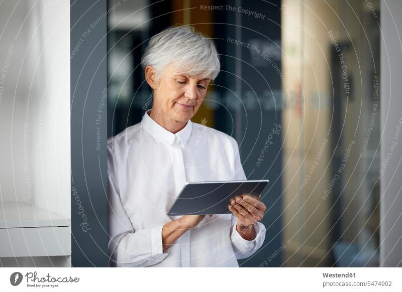 Portrait einer älteren Geschäftsfrau mit digitalem Tablet im Büro geschäftlich Geschäftsleben Geschäftswelt Geschäftsperson Geschäftspersonen Businessfrau