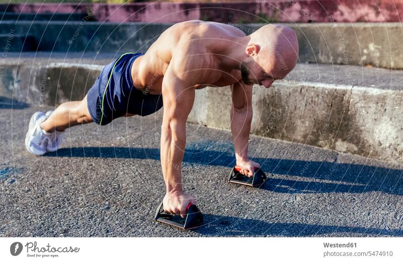 Muskulöser Mann mit nacktem Oberkörper macht Liegestütze im Freien muskulös Muskeln athletisch trainieren Liegestützen Push-Up Pushups Push-Ups Männer männlich