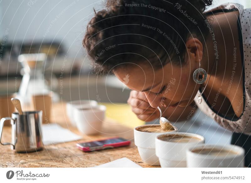 Frau arbeitet in einer Kaffeerösterei und riecht nach Produkt Job Berufe Berufstätigkeit Beschäftigung Jobs Leute Menschen People Person Personen gelockt