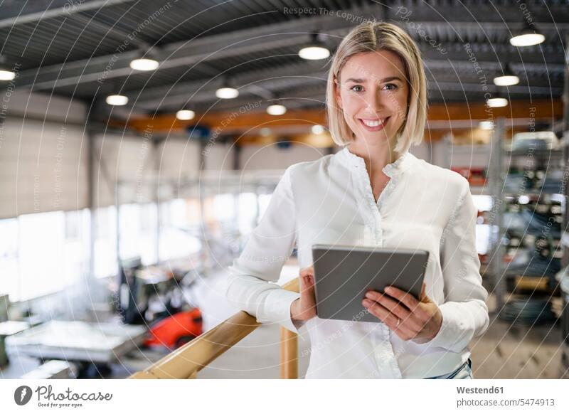 Porträt einer lächelnden jungen Frau mit Tablette in einer Fabrik Leute Menschen People Person Personen Europäisch Kaukasier kaukasisch 1 Ein ein Mensch