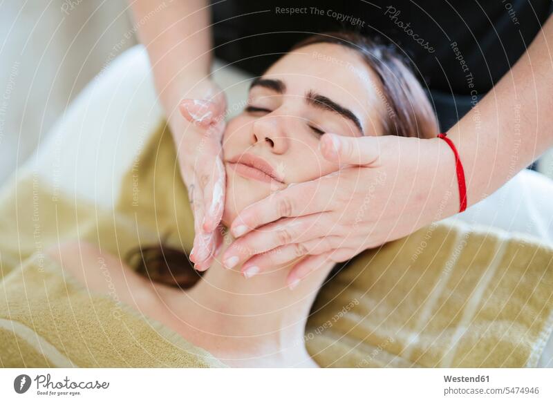 Junge Frau erhält Gesichts-Schönheitsbehandlung in einem Spa (value=0) Handtuecher Handtücher Cremes Liegen cremen Massage anfassen Berührung entspannen relaxen