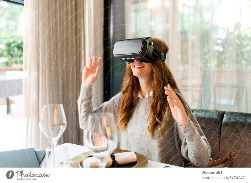 Frau sitzt am Tisch in einem Restaurant und trägt eine VR-Brille Lokal Speiserestaurant Lokale Speiselokale Restaurants Speiserestaurants Virtual Reality Brille