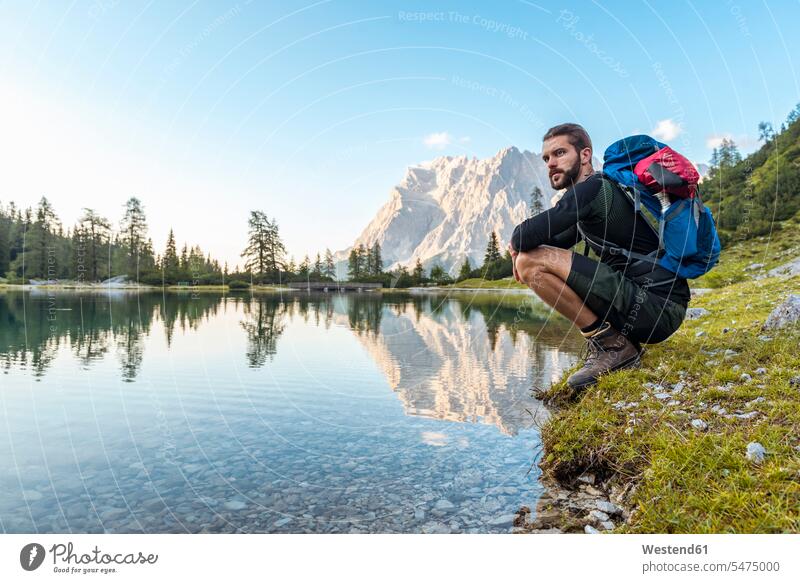 Österreich, Tirol, Wanderer bei einer Pause, kauernd am See Pause machen Seeufer hocken hockend Schönheit der Natur Schoenheit der Natur sitzen sitzend sitzt