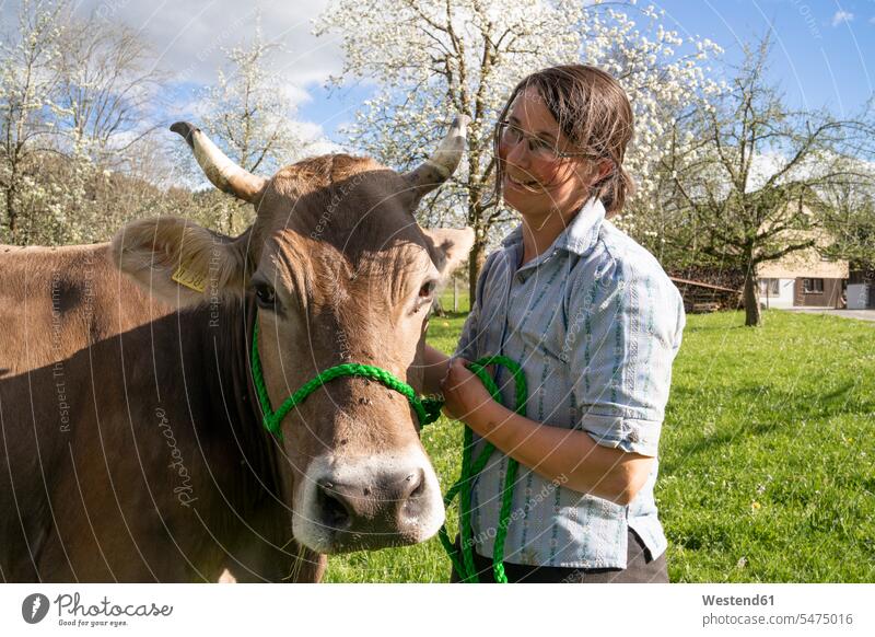 Lächelnder Landwirt mit einer Kuh auf der Weide Leute Menschen People Person Personen Europäisch Kaukasier kaukasisch Südeuropäisch 1 Ein ein Mensch