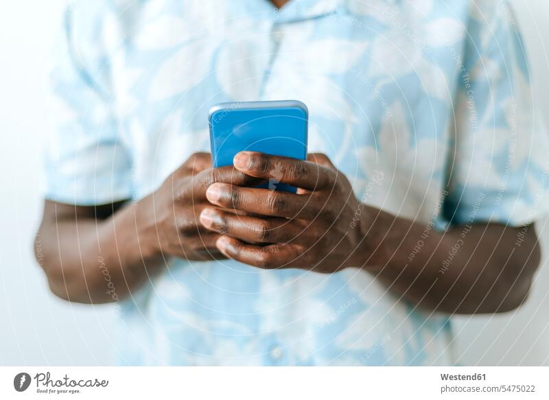 Nahaufnahme eines Mannes, der ein Mobiltelefon hält Leute Menschen People Person Personen Afrikanisch Afrikanische Abstammung dunkelhäutig Farbige Farbiger