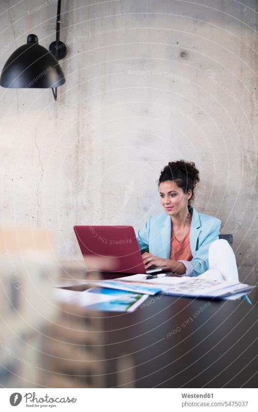 Geschäftsfrau sitzt am Tisch in einem Loft mit Laptop Tische Notebook Laptops Notebooks Geschäftsfrauen Businesswomen Businessfrauen Businesswoman Lofts sitzen