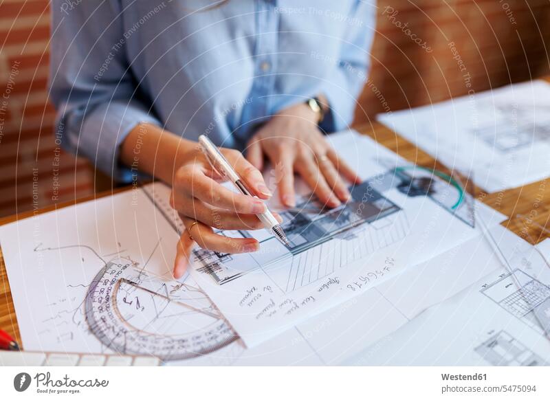 Junge Frau, die im Architekturbüro arbeitet und Blaupausen zeichnet Architektin Architektinnen zeichnen Zeichnung Bauplan Architekturplan Konstruktionsplan