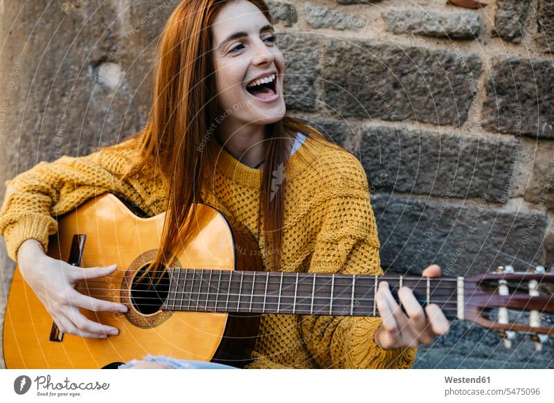 Rothaarige Frau spielt die Gitarre in der Stadt Sängerin Musikerin Musikerinnen weiblich Frauen Leidenschaft leidenschaftlich Leidenschaftlichkeit Gitarren