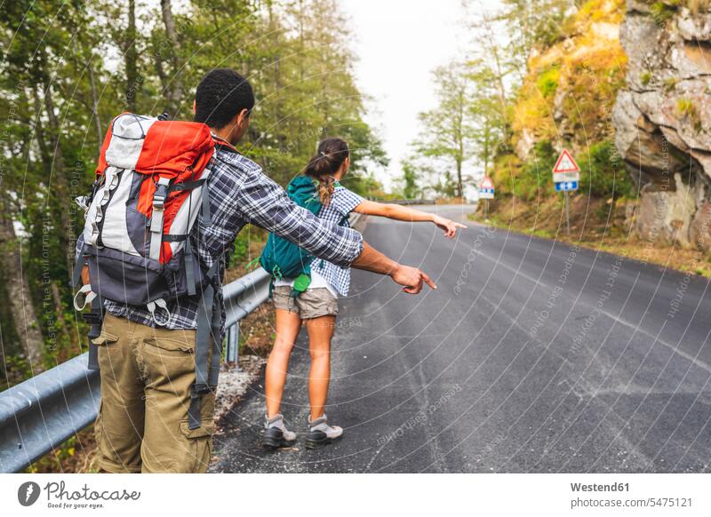Italien, Massa, Pärchen trampen auf einer Straße in den Alpi Apuane Bergen Anhalter per Autostopp fahren per Anhalter fahren Strassen Paar Paare Partnerschaft