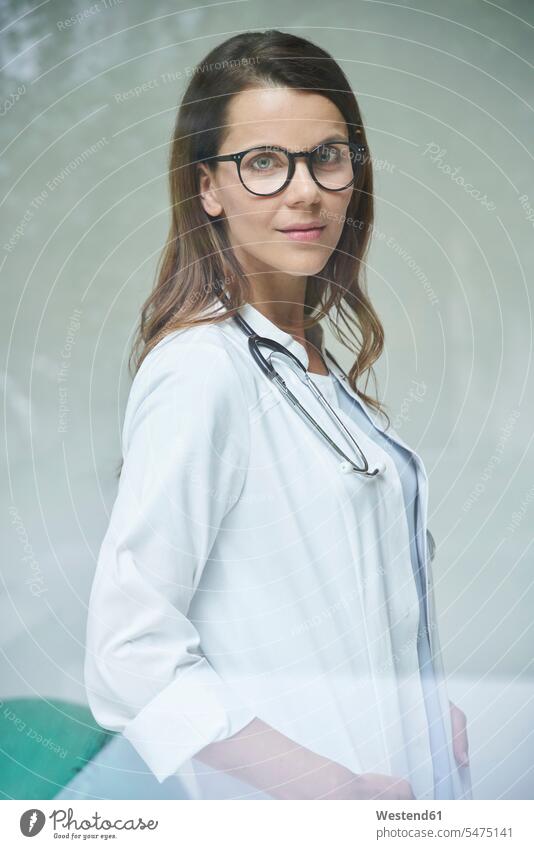 Porträt einer selbstbewussten Ärztin hinter einer Fensterscheibe Job Berufe Berufstätigkeit Beschäftigung Jobs Fensterscheiben Gesundheit Gesundheitswesen