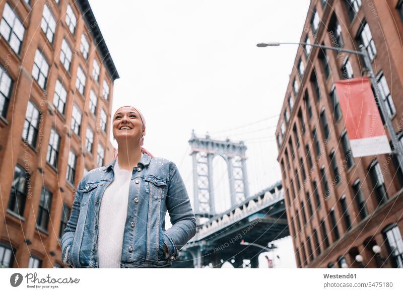 Lächelnde Frau mit Krebstuch an der Manhattan Bridge in New York, USA Spass spassig spaßig Spässe Späße amusieren Amüsement Freude freuen genießen vergnügt