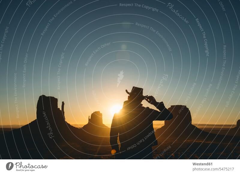USA, Utah, Monument Valley, Silhouette eines Mannes mit Cowboyhut bei Sonnenaufgang Sonnenaufgänge Umriß Gegenlicht Schattenbilder Silhouetten Konturen Umriss