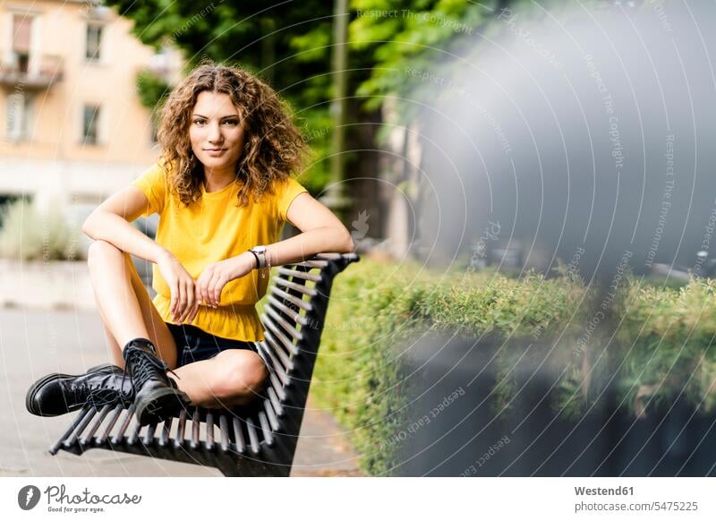Porträt einer selbstbewussten jungen Frau, die auf einer Bank sitzt Leute Menschen People Person Personen Europäisch Kaukasier kaukasisch 1 Ein ein Mensch