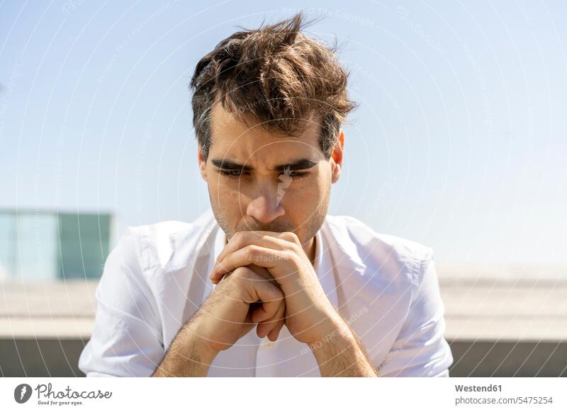 Porträt eines ernsten Geschäftsmannes im Freien Barcelona denken nachdenken überlegen wolkenlos ohne Wolken Textfreiraum wehende Haare wehendes Haar aufstützen