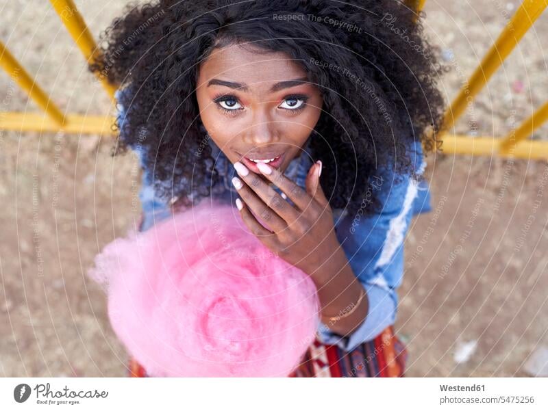 Porträt einer jungen Frau mit rosa Zuckerwatte Leute Menschen People Person Personen Afrikanisch Afrikanische Abstammung dunkelhäutig Farbige Farbiger Schwarze