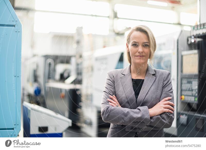 Porträt einer selbstbewussten Frau in einer Fabrikhalle Portrait Porträts Portraits weiblich Frauen Fabriken Industriehallen Fabrikhallen Zuversicht
