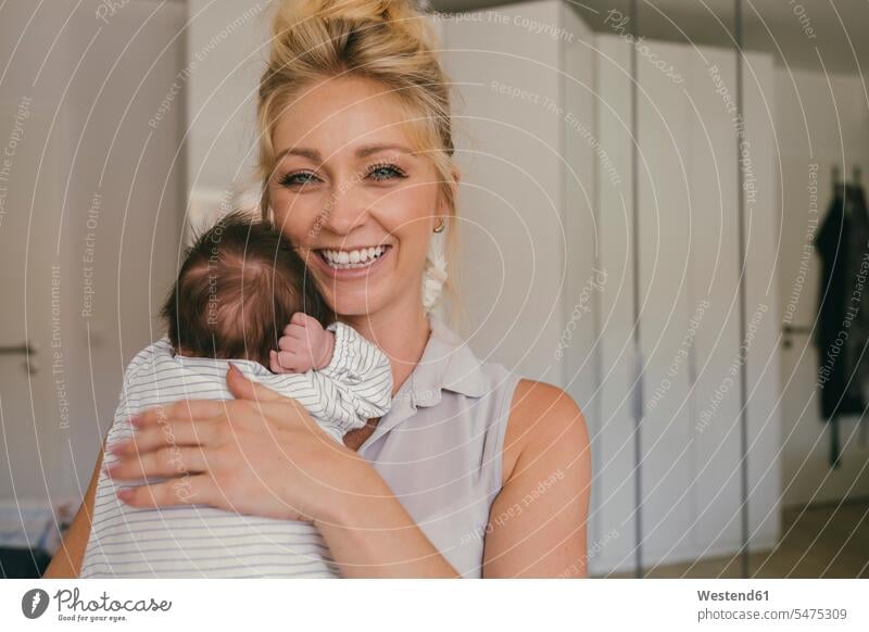 Porträt einer glücklichen Mutter, die ihr Baby dicht an ihrer Schulter hält Portrait Porträts Portraits halten Mami Mutti Mütter Mama Glück glücklich sein