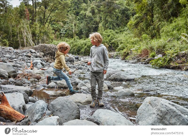 Chile, Patagonien, Vulkan Osorno, Wasserfall Las Cascadas, zwei Jungen spielen an einem Fluss Fluesse Fluß Flüsse Bruder Brüder Buben Knabe Knaben männlich