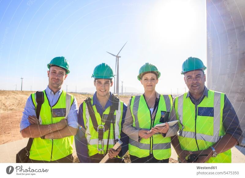 Porträt von vier lächelnden Ingenieuren auf einem Windpark Portrait Porträts Portraits Windenergieanlage WEA WEAs Windkraftwerk Windenergieanlagen