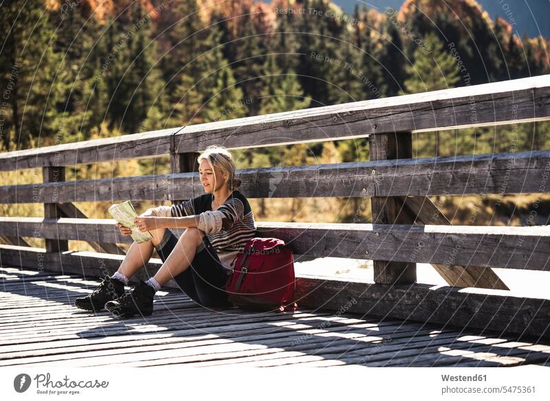 Österreich, Alpen, junge Frau mit Rucksack auf einer Brücke sitzend und eine Pause machend Europäer Europäisch Kaukasier kaukasisch reife Frau reife Frauen