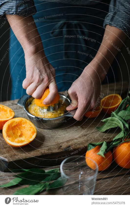 Hände eines jungen Mannes, der eine Orange auspresst Hand Citrus sinensis Apfelsinen Orangen Männer männlich auspressen Mensch Menschen Leute People Personen