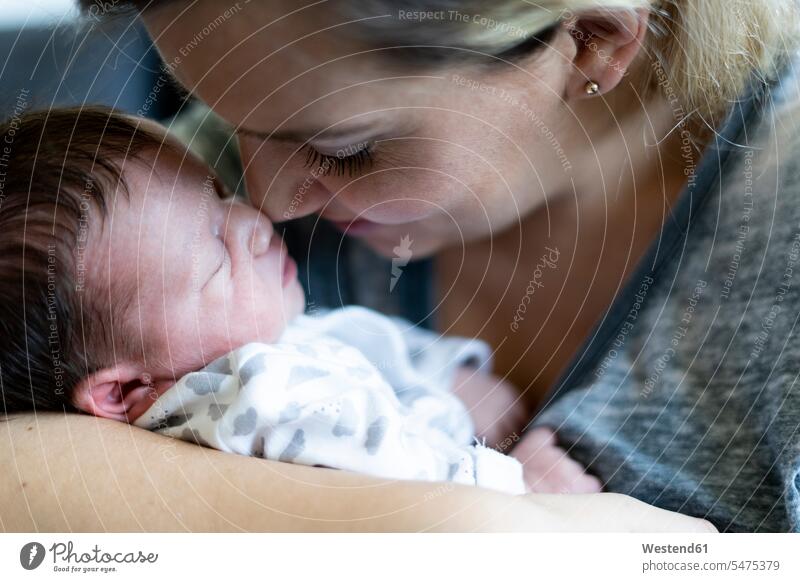 Nahaufnahme einer Mutter, die ihr neugeborenes Baby hält berühren Berührung anfassen Augen geschlossen geschlossene Augen genießen geniessen Genuss Gemeinsam