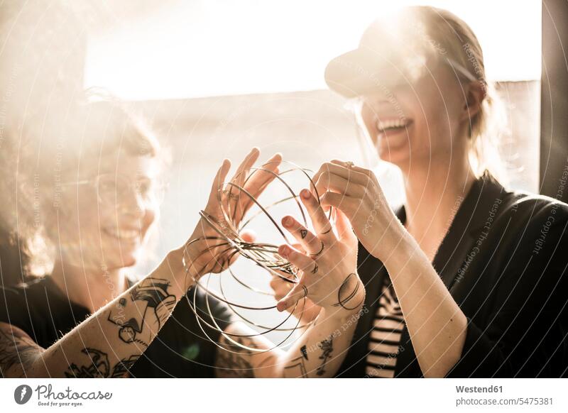 Designer spielt mit Ringformen Deutschland Kreative Kreativer Kreativer Beruf Work-Life-Balance Digitalisierung Kollegin Kolleginnen offenes Lächeln lachen