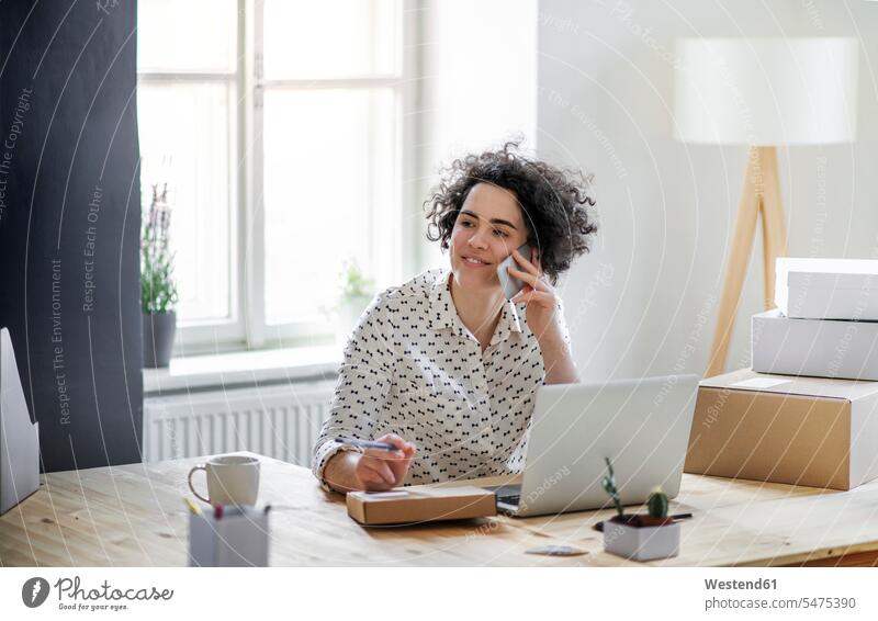 Lächelnde junge Frau am Telefon im Home-Office Job Berufe Berufstätigkeit Beschäftigung Jobs geschäftlich Geschäftsleben Geschäftswelt Geschäftsperson