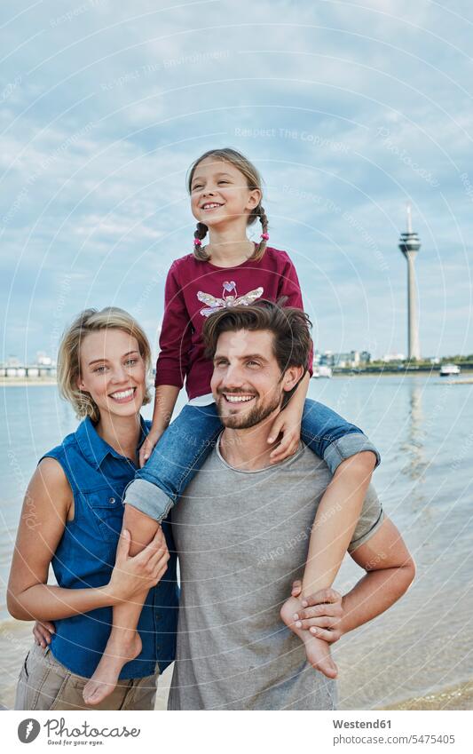 Deutschland, Duesseldorf, glueckliche Familie mit Tochter am Rheinufer Familien Flussufer Zuneigung Töchter Fluesse Fluß Flüsse glücklich Glück glücklich sein