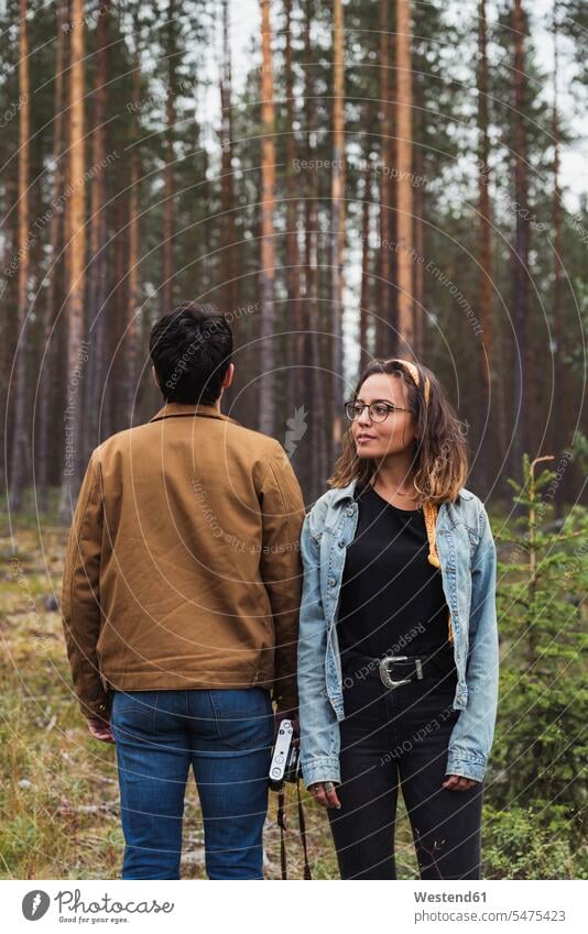 Finnland, Lappland, Mann mit Kamera und Frau stehen in ländlicher Landschaft Landschaften Paar Pärchen Paare Partnerschaft Fotoapparat Fotokamera stehend steht