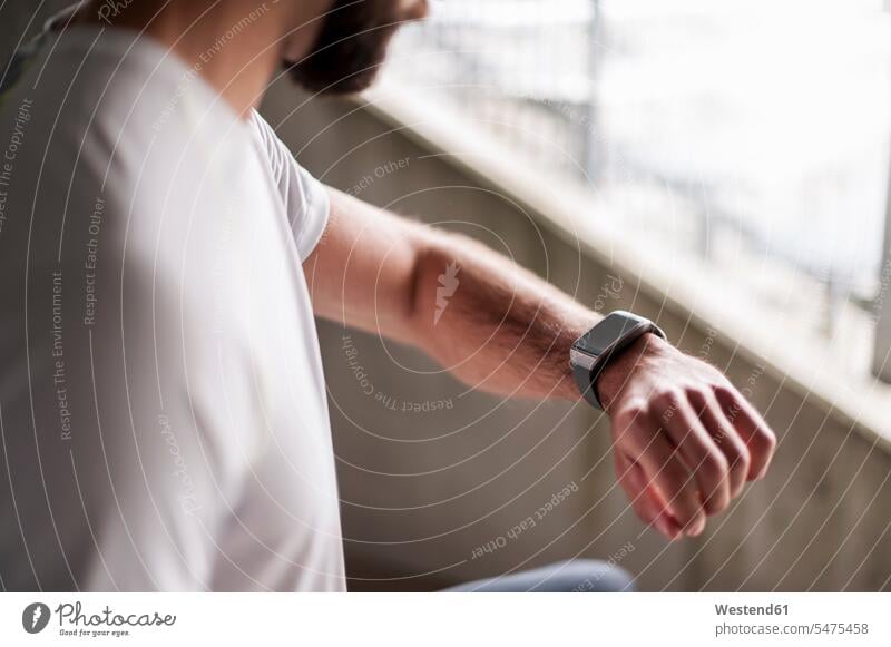 Sportler, der die Zeit auf einer Smartwatch kontrolliert Mann Männer männlich checken Erwachsener erwachsen Mensch Menschen Leute People Personen sportlich