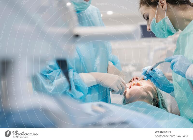 Junge Frau erhält Zahnbehandlung in Klinik Job Berufe Berufstätigkeit Beschäftigung Jobs Lösungen Kooperation Teamwork zusammen arbeiten zusammenarbeiten