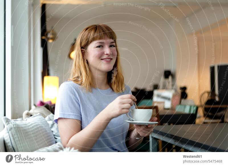 Porträt einer erdbeerblonden jungen Frau mit Nasenpiercing bei einer Tasse Kaffee in einem Cafe Leute Menschen People Person Personen Europäisch Kaukasier